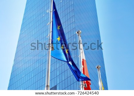 Polish and European union flags, flying and waving with glass wall office building background