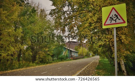 The road sign - children, attention. Autumn, little town.