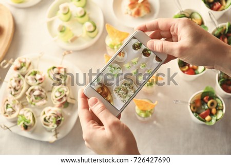 Blogger making photo of food with cell phone