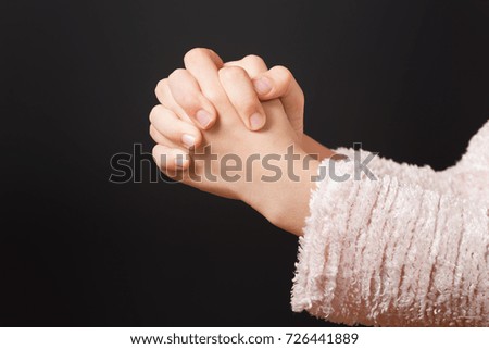 A close up of a young girl`s hands while praying.