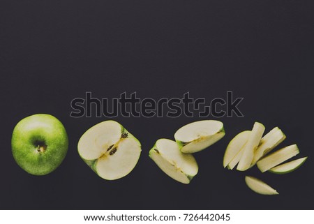 Stages of cutting green apple on black background. Chopping fresh fruit, cooking healthy food, copy space
