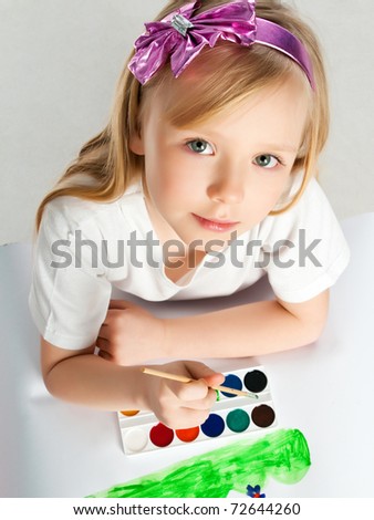 cute little girl with a brush and paints