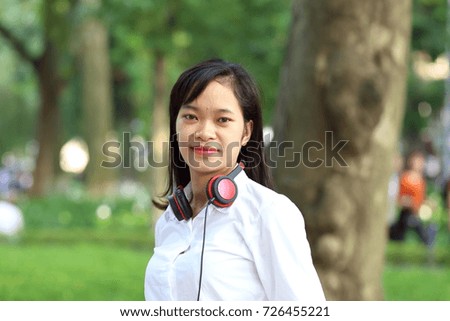 Young woman listening to music on a smartphone in Hanoi