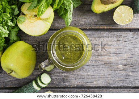 Green detox smoothie in a glass with fruits and vegetables . Top view , space for text 