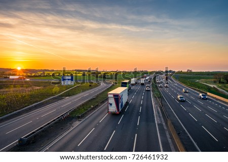 Colorful sunset at M1 motorway near Flitwick junction with blurry cars in United Kingdom Royalty-Free Stock Photo #726461932