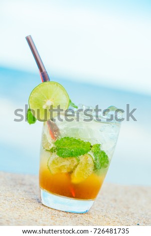Ice drinking cocktails mojito glass with sea and ocean background