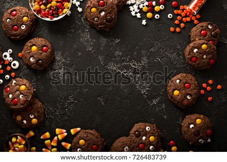Chocolate monster cookies with candy, homemade treats for Halloween overhead shot with copy space