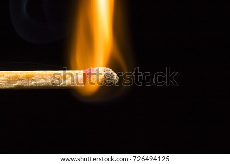 Match on fire on the left side of the corner on a black background