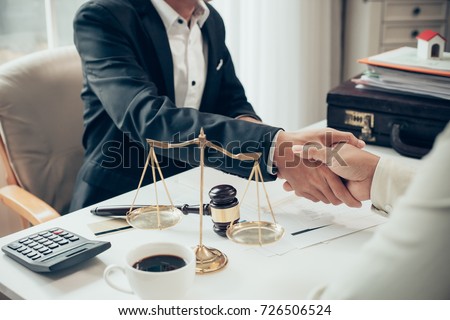 Businessman shaking hands to seal a deal with his partner lawyers or attorneys discussing a contract agreement Royalty-Free Stock Photo #726506524