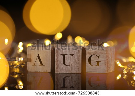Month Concept, front view shows wooden block written Aug with light and bokeh background