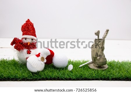 Snowman with golf bag are on green grass