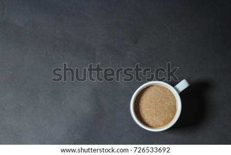 Cup of coffee on grey background, top view 