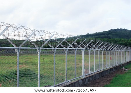 Metal fence wire, War and sky in the background in Phuket Thailand