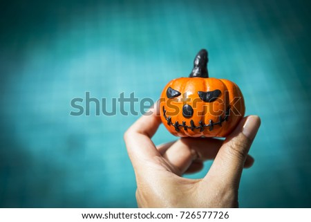 Halloween background concept, funny pumpkin over blurred blue water background, vintage tone style