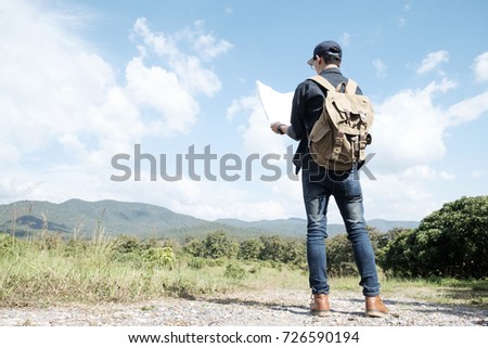 Young Man Traveler with backpack relaxing outdoor. Summer vacations and Lifestyle hiking concept. Retro filter effect, selective focus