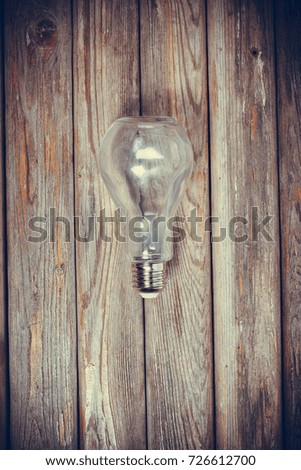 Bottle in the shape of a light bulb on a wooden surface of a vintage style