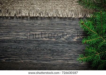 Vintage sackcloth pine branch on wooden board Christmas background.
