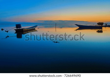 Two small boat on the water at sunrise with reflection. Royalty-Free Stock Photo #726649690