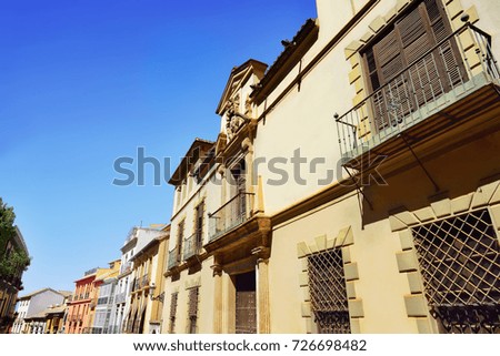 Classic apartment buildings with balcony and colorful paint wall along the street in Spain