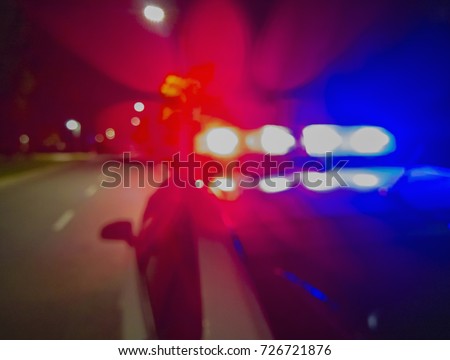 Police car lights in night time, crime scene. Night patrolling the city. Abstract blurry image.