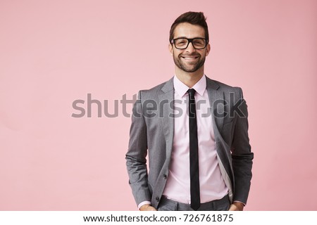 Happy grey suit guy in pink studio, portrait