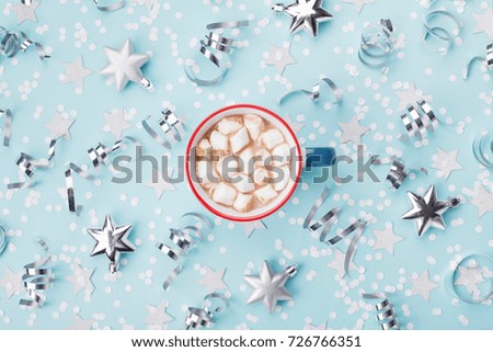 Cup of hot cocoa or chocolate with marshmallow on blue christmas background top view. Flat lay. Holiday celebration concept.