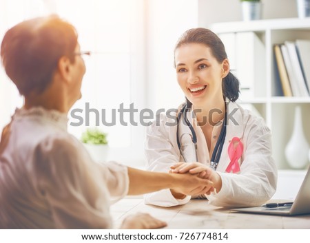 Pink ribbon for breast cancer awareness. Female patient listening to doctor in medical office. Raising knowledge on people living with tumor illness. Royalty-Free Stock Photo #726774814