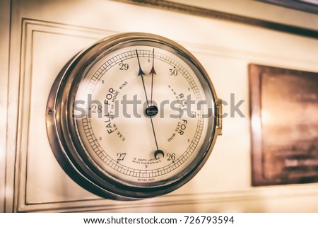 Very old aneroid barometer on the wall at the cabin of the sail ship; Vintage style effect Royalty-Free Stock Photo #726793594