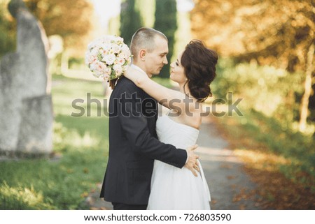 Beautiful romantic wedding couple of newlyweds hugging in green park