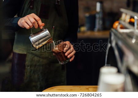 Barista making hot chocolate, coffee shop  