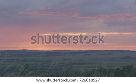 Natural Sunrise Over Field Or Meadow. Bright Dramatic Sky And Dark Ground. Countryside Landscape Under Scenic Colorful Sky At Sunset Dawn Sunrise. Sun Over Skyline, Horizon. Warm Colours