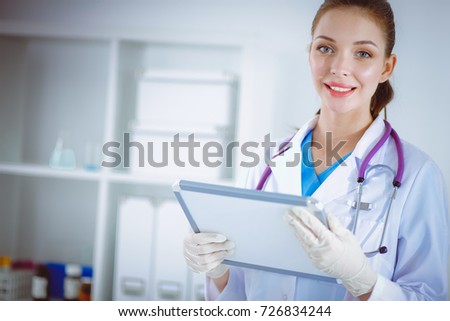 Woman doctor standing with folder at hospital. Woman doctor