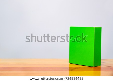 Empty Package green cardboard box mock up for product items on bright wooden table with copy space.