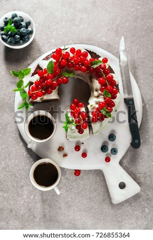 bundt cake with fresh berries and sauce from sour cream on grey stone table and two cups of espresso coffee. happy break