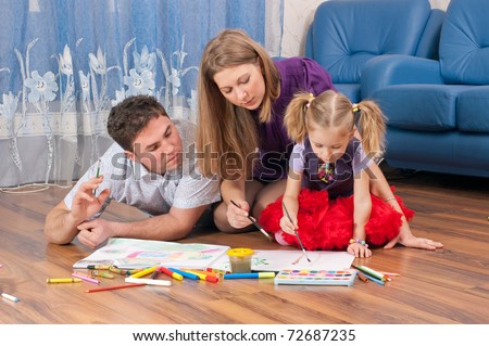 Family amicably draw on a floor