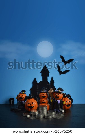 Halloween pumpkins jack-o-lantern with money coin stack growing business on dark blue background. Happy Halloween.