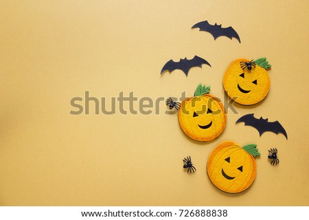 Flat lay Halloween background with decorative pumpkins, spiders and bats on orange background. Blank space for text. Festive  concept. 
