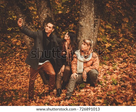 Friends making selfie in an autumn park