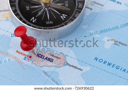  Travel concept on world map with destination lock pin and compass.