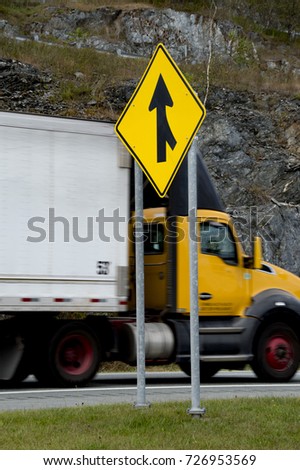 Merge Road Sign Between Interstate And Parking Area, Truck Driving Past