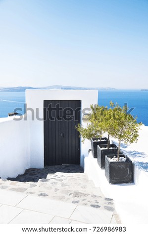 Traditional Greek architecture and a view of the blue sea over a white terrace. Santorini, Cyclades, Greece.