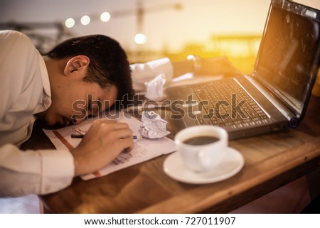 A civil engineer is sleeping on the working table after he clarified the margin target and construction schedule for his company in over time on wooden working table.selected focus at a part of paper. Royalty-Free Stock Photo #727011907