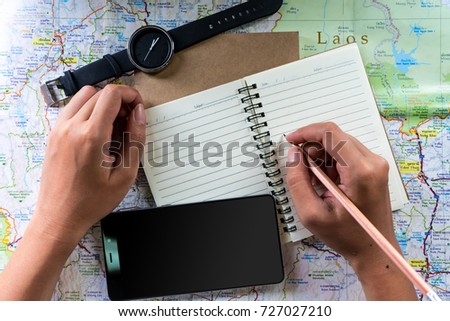 Tourists are planning a trip to see the beauty in Thailand with maps and notebooks while on the train.