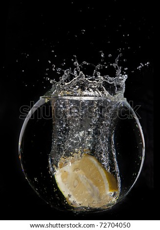 Yellow lemon half in water splash on dark background