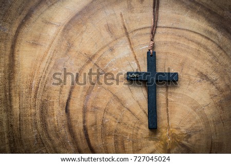 A mini cross on the wood table.
