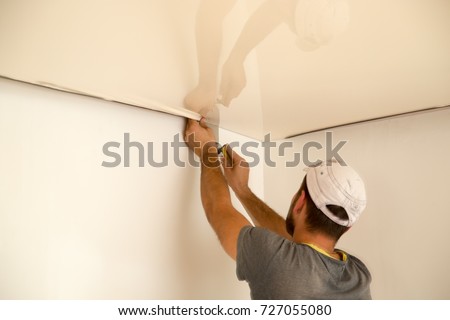 Workers stretch the stretch ceiling in the room Royalty-Free Stock Photo #727055080