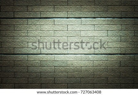 Brick wall with gray stain, light in the middle for background or wallpaper.