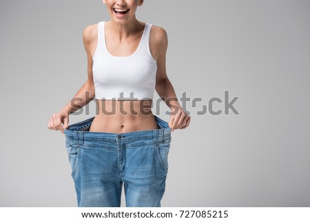Happy girl showing her slim figure after workout Royalty-Free Stock Photo #727085215