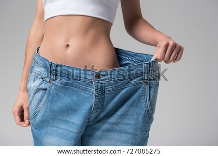Slim girl wearing oversized pants Royalty-Free Stock Photo #727085275