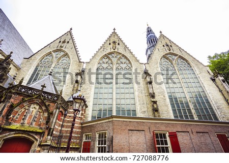 Frontal picture of the Old Church (Oude Kerk) facade, located in the Red Light District, Amsterdam, in a cloudy day.